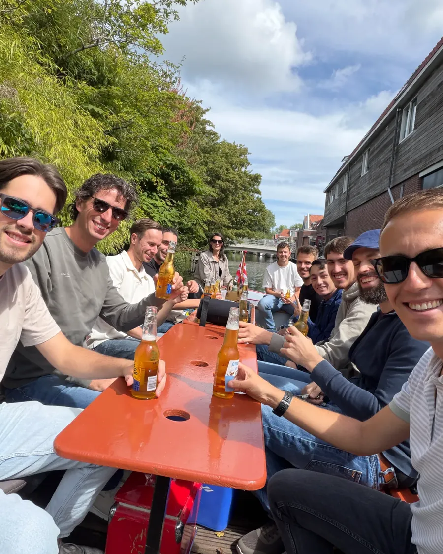 Het team van Hatch aan tafel op een boot, tijdens een teamuitje